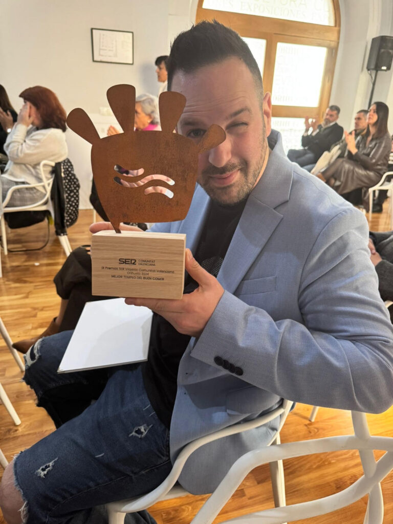 Hombre sosteniendo un premio en evento.